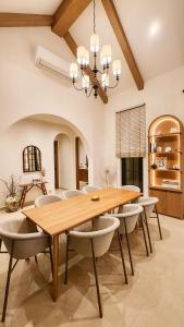a dining room with a wooden table and chairs at La Moon Da Villa Khaoyai in Ban Bung Toei