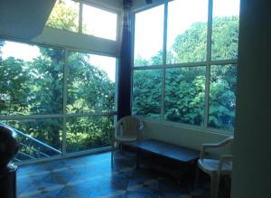 a room with a bench in front of a window at Corbett view homestay in Belparāo