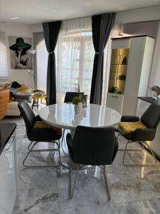 ein Esszimmer mit einem weißen Tisch und Stühlen in der Unterkunft Exklusive Villa am Sonnenstrand Bulgarien am Schwarzen Meer aheloy Cabernet 1 in Kableshkovo