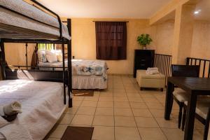 a bedroom with two bunk beds and a table and a dining room at Casa Chukum en Rio Lagartos in Río Lagartos