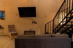 a living room with a couch and a tv on the wall at Casa Chukum en Rio Lagartos in Río Lagartos