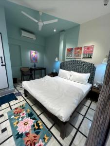 a bedroom with a large white bed with a flower rug at Boho BB Villa near Nakki Lake in Mount Ābu