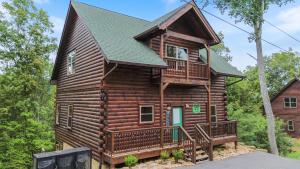a log cabin with a porch and a deck at 200 Pines- Log Cabin with Fall Views, Hot tub & Indoor Pool in Sevierville