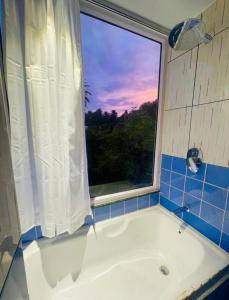a bathroom with a bath tub with a window at Boho Mount Abu in Mount Ābu +39 photos