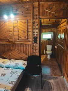 a bedroom with a bed and a toilet in a room at Cabana "Tăul Brazi" in Roşia Montană