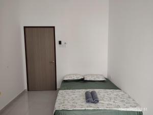 a bed in a room with two pairs of shoes on it at Teratak Asyakira in Bedung