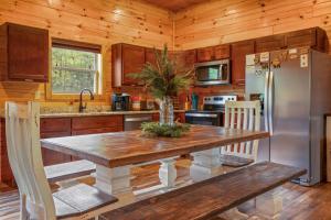 a kitchen with a table and a refrigerator at 200 Pines- Log Cabin with Fall Views, Hot tub & Indoor Pool in Sevierville