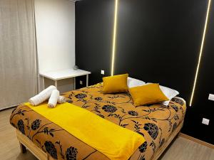 1 dormitorio con 1 cama con sábanas amarillas y almohadas amarillas en La Suite Mulhouse, en Mulhouse