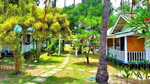 a house with palm trees in front of it at Oasi - bungalow in Gili Air