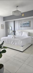 マイアミにあるIcon brickell 48fl river viewの白いベッドルーム(白いベッド1台、シャンデリア付)