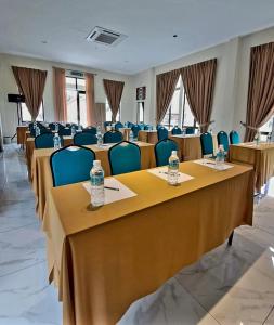 a conference room with tables and chairs with water bottles on them at Cinta Abadi Resort in Bidur