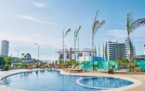 una piscina con bancos y palmeras en una ciudad en Loft, en Manta