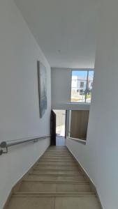 una escalera en un edificio blanco con ventana en Loft, en Manta