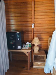 a small table with a television and a lamp on it at Arta dani villas in Sidemen +61 photos
