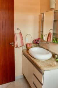 a bathroom with a sink and a mirror at Paraíso Tropical em Porto Seguro in Porto Seguro
