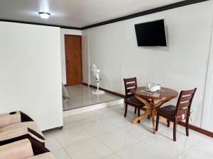 a living room with a table and chairs and a television at Apartment Open House in Managua