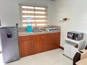 a kitchen with a stainless steel refrigerator and a microwave at Apartment Open House in Managua