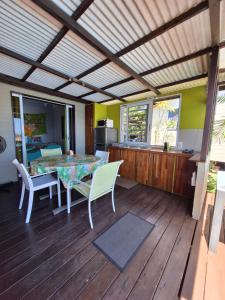une salle à manger avec une table et des chaises sur une terrasse dans l'établissement Cozy bungalow vue exceptionnelle sur l'océan, à Punaauia