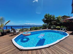 - une piscine sur une terrasse avec vue sur l'océan dans l'établissement Cozy bungalow vue exceptionnelle sur l'océan, à Punaauia