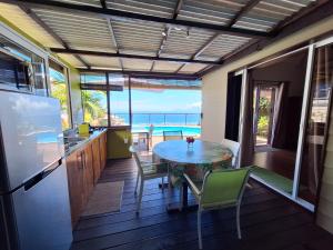 une cuisine et une salle à manger avec une table et des chaises dans l'établissement Cozy bungalow vue exceptionnelle sur l'océan, à Punaauia