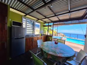 une cuisine avec une table et une vue sur l'océan dans l'établissement Cozy bungalow vue exceptionnelle sur l'océan, à Punaauia