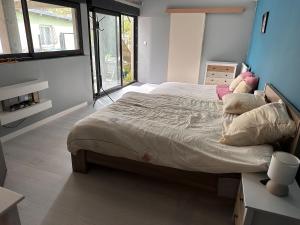 a bedroom with a large bed in a room with windows at Chambre pour 4 personnes avec SdB privative et jacuzzi in Le Petit-Couronne