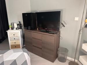 a living room with a flat screen tv on a dresser at Chambre pour 4 personnes avec SdB privative et jacuzzi in Le Petit-Couronne