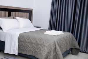 a bedroom with a bed with a gray comforter at The Parresia Haven in Harare