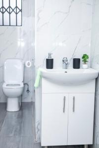 a white bathroom with a sink and a toilet at The Parresia Haven in Harare +29 photos
