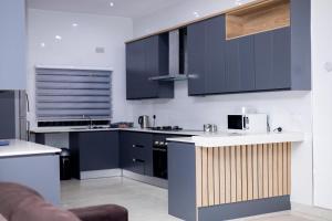 a kitchen with dark blue cabinets and a counter top at The Parresia Haven in Harare