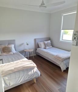 ein Schlafzimmer mit zwei Betten und einem Fenster in der Unterkunft The Cottage in Moruya