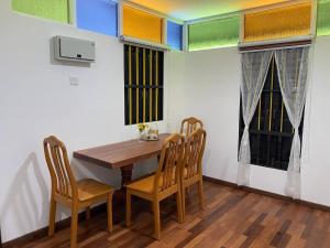 Un comedor con mesa y sillas de madera. en Rumah Inap Kampung Agong Sunrise, en Penaga