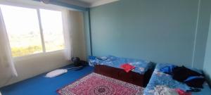 a blue room with a bed and a window at Koirala Home's in Changunarayan