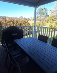 ein blauer Tisch und zwei Stühle auf einer Veranda in der Unterkunft The Cottage in Moruya