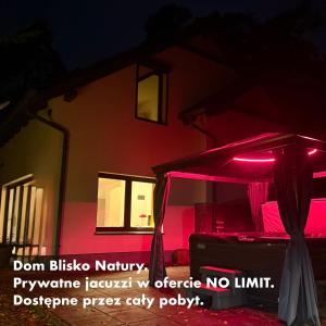 una tenda rossa di fronte a un edificio di notte di Dom Blisko Natury Boszkowo Letnisko Dom A a Boszkowo-Letnisko