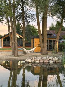 una casa con una hamaca colgada entre dos árboles en Lakeview Houses, en Gil Mały