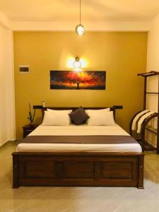 a bedroom with a bed in a yellow wall at Hiriketiya Green Haven Villa in Dickwella