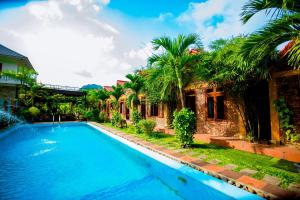 a swimming pool in front of a house at Hillside Homestay in Dong Hoi