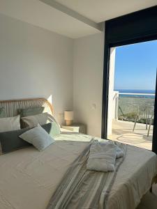 a bedroom with a large bed with a view of the ocean at Les Flors de Cunit Villa Cedra in Cunit +37 photos