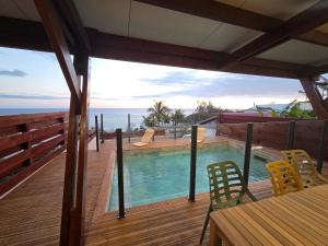 a deck with a pool and a table and chairs at Villa Petite Anse in Petite Île