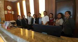 a group of people standing in front of a computer at V Hotel and Apartel in Baguio