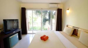 ein Hotelzimmer mit einem Bett mit einem Fernseher und einem Bett sidx sidx sidx sidx in der Unterkunft The Room Hotel in Nakhon Phanom