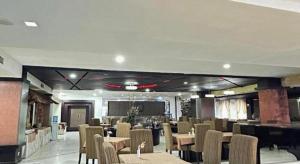 a dining room with tables and chairs in a room at Travello Hotel Manado in Manado