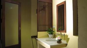 a bathroom with a sink and a mirror at Baan Lapoon Hotel in Lamphun +60 photos