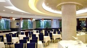 a dining room with white tables and blue chairs at Changchun Global Hotel in Changchun