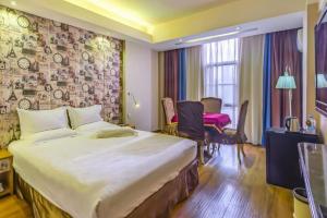Biway Fashion Hotel - Puyang Lianhua في Puyang: غرفة فندقية بها سرير كبير ومكتب +250 صورة