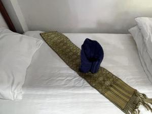 a bed with a hat and a tie on it at Mountain View dormitory in Ban Sôphoun +10 photos