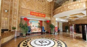 a lobby of a building with a painting on the wall at Shengshi Jinhua Hotel in Shenzhen