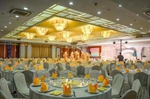 a large banquet hall with white tables and chairs at Huzhou Zhebei Hotel in Huzhou