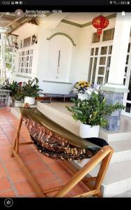 a porch of a house with potted plants on it at BONNIE HOMESTAY Mui Ne in Mui Ne